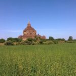 a large building with a tower in the middle of a field