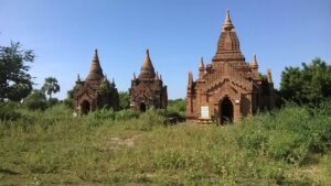 a group of brick buildings in a field