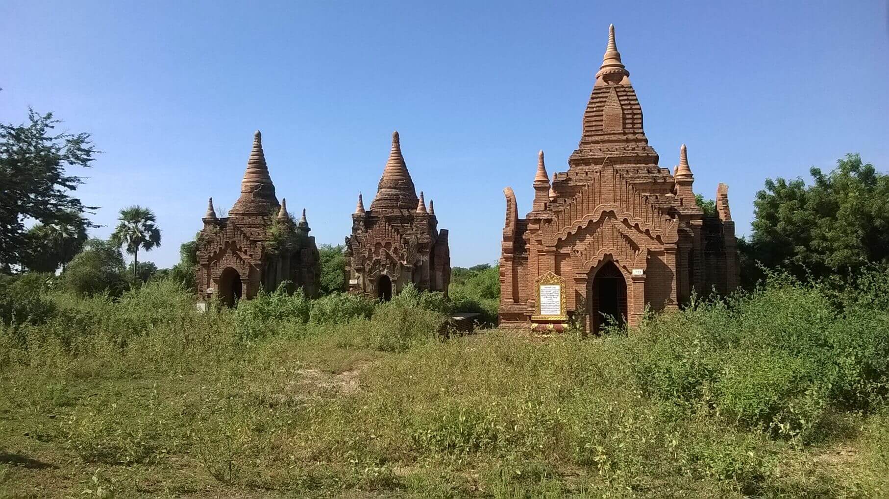 a group of brick buildings in a field