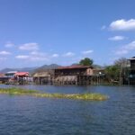 a group of houses on stilts on a river